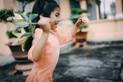 女孩拿着一个黄色的花在运行
